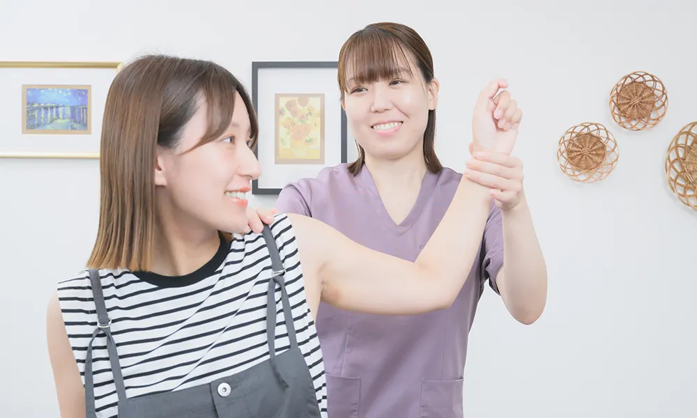 女性の体の痛みを検査をする整体師