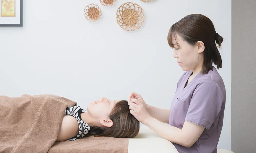 女性の体の痛みを検査をする整体師