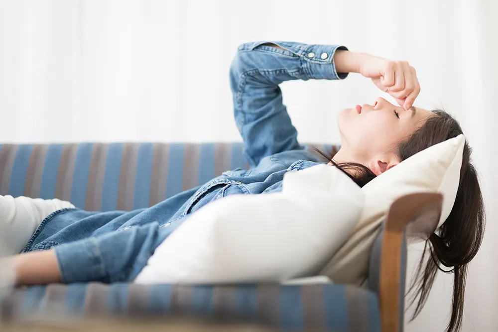 ソファで横になる女性