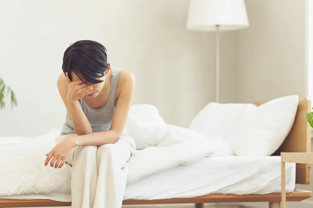 ベッドでため息をつく女性