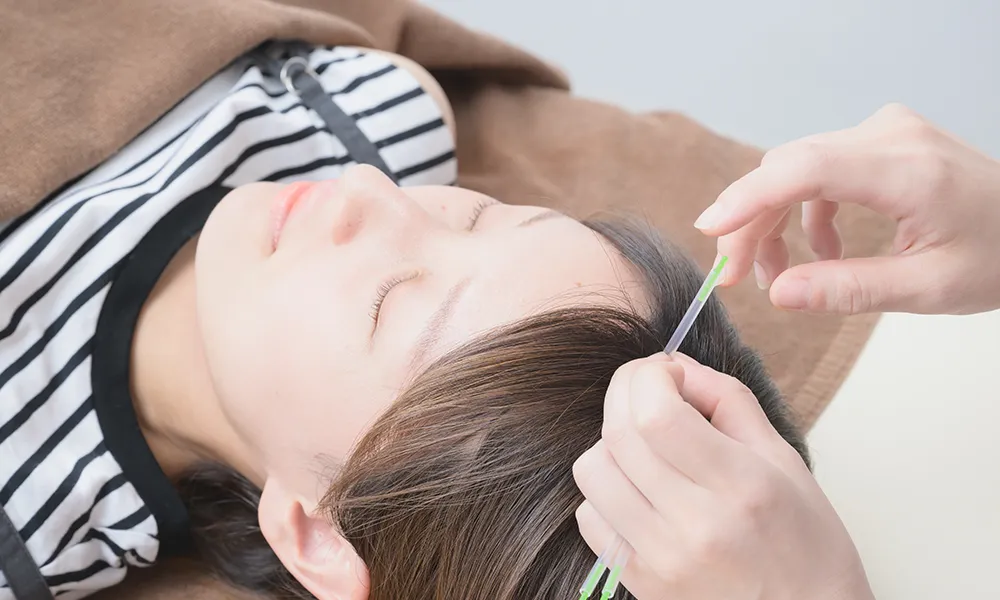 女性の体の痛みを検査をする整体師